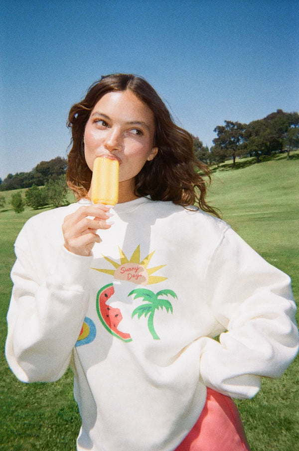 Woman wearing white sweater against a green background