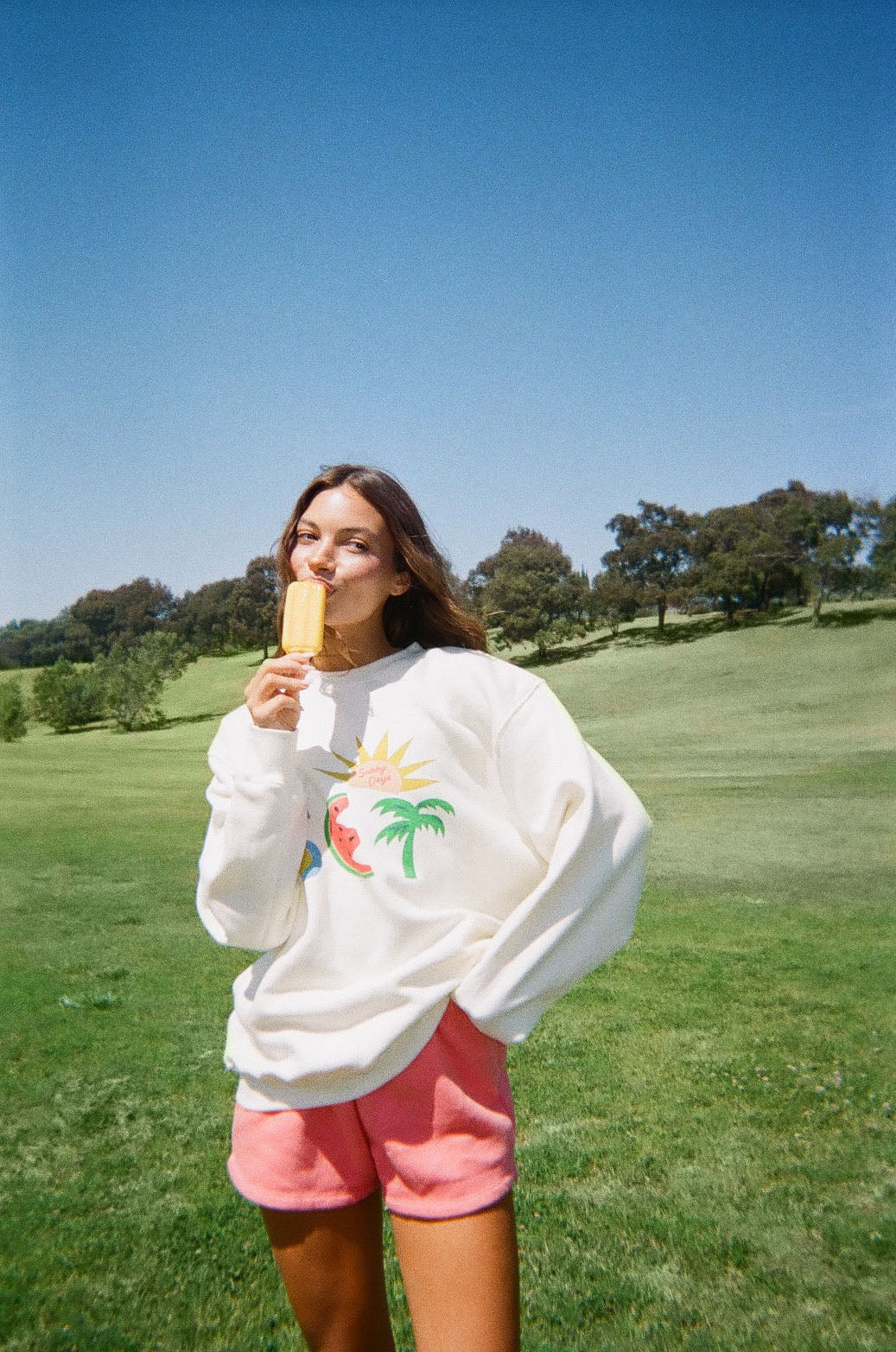 Woman wearing white sweater against a green background
