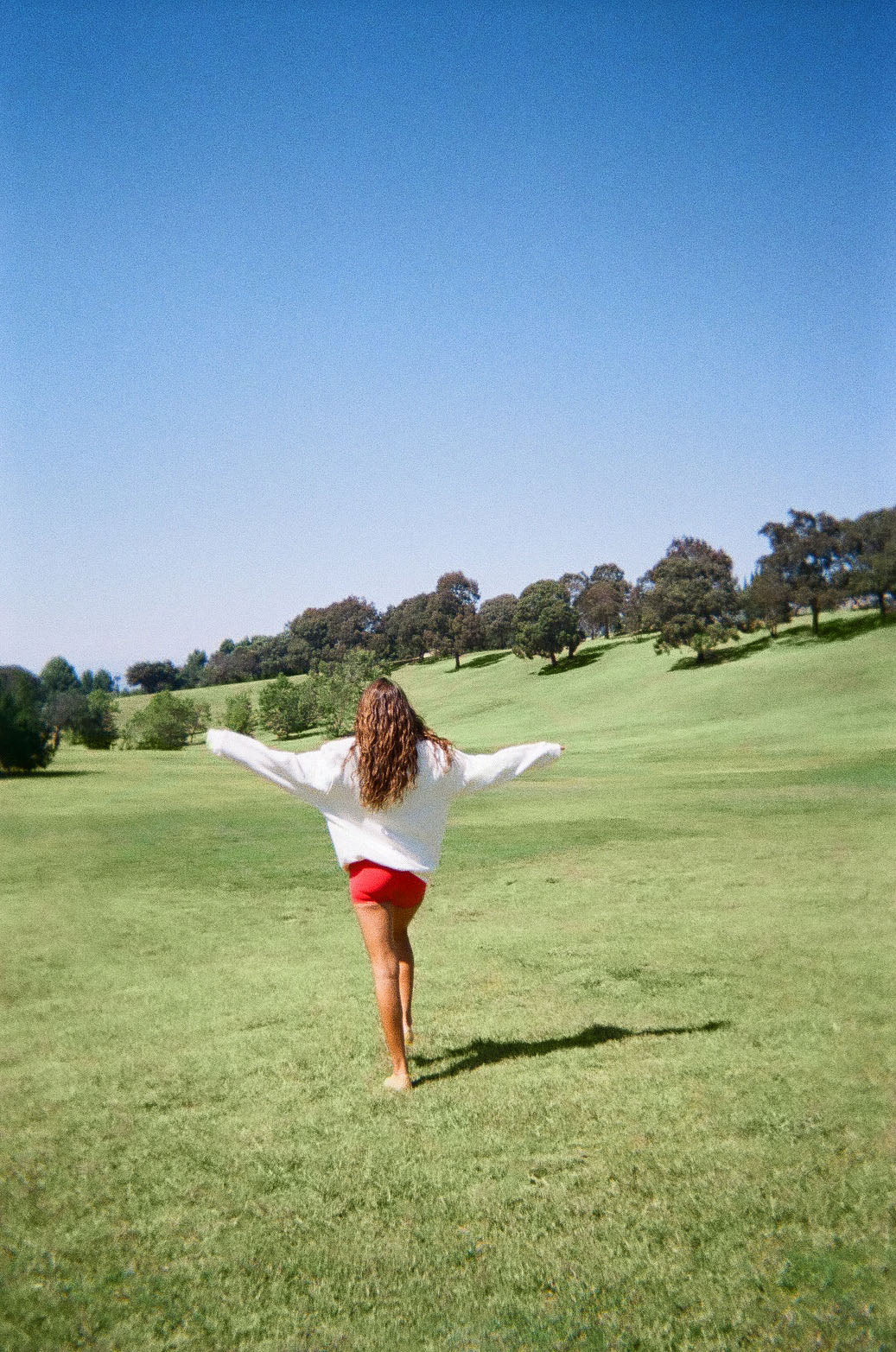 Woman wearing white sweater against a green background