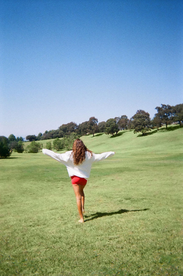 Woman wearing white sweater against a green background