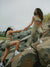 Two women in matching athletic wear standing on rocks outdoors