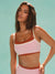 Woman wearing a two-tone sports bra and leggings against a light blue background
