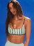 Woman wearing a green and white striped bra top against a blue background