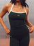 A woman wearing a dark forest green athletic tank top and matching leggings with white trim and a small white 'SET' logo, shown from the neck down against a gray studio backdrop. <model-info>Alana wears a size M and is 5’8”, 28” waist, 35" bust.</model-info>