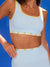 Light blue sports bra with yellow accents and 'SET' branding against a blue background