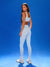 Woman wearing a light blue athletic outfit with a brown top on a blue background