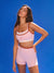 Woman wearing a pink sports bra and shorts set against a blue sky <model-info>Kushi wears a size S and is 5'8, 24” waist, 32C bust.</model-info>