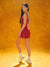 Woman in a red outfit standing against an orange background