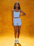 Woman wearing a light blue athletic outfit against an orange background