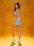 Woman in light blue athletic outfit standing against a textured orange background