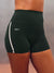 Close-up of a model wearing black high-waisted athletic shorts with a white side stripe and the brand name 'SET' printed in white on the hip, against a neutral gray background. <model-info>Scha'leigh wears a size XS and is 5’8”, 24” waist, 32B bust.</model-info>