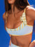 Woman wearing a striped sports bra against a blue background