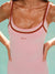 Pink tank top with brown straps on a person against a light blue background