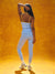Person wearing a sports bra and leggings on an orange background