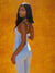 Woman wearing a light blue jumpsuit with yellow trim against an orange background
