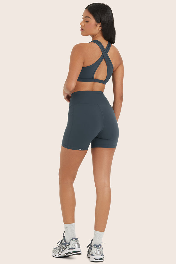 MODEL WEARS AIRLUXE™ BREATHE POCKET SHORTS IN COMPASS 