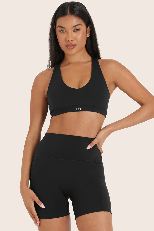 MODEL WEARS AIRLUXE™ BREATHE TRACK BRA IN ONYX 