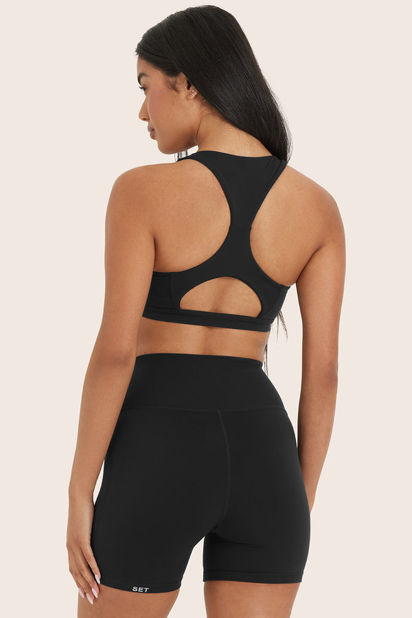 MODEL WEARS AIRLUXE™ BREATHE TRACK BRA IN ONYX 