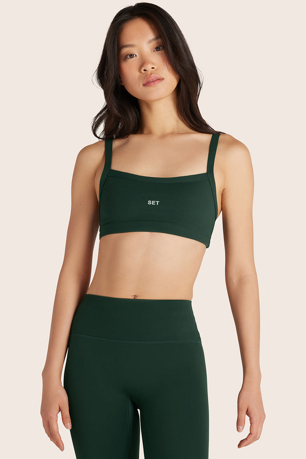 MODEL WEARS SPORTBODY® (BLOOPERS) SPORTY SCOOP BRA IN BEETLE 