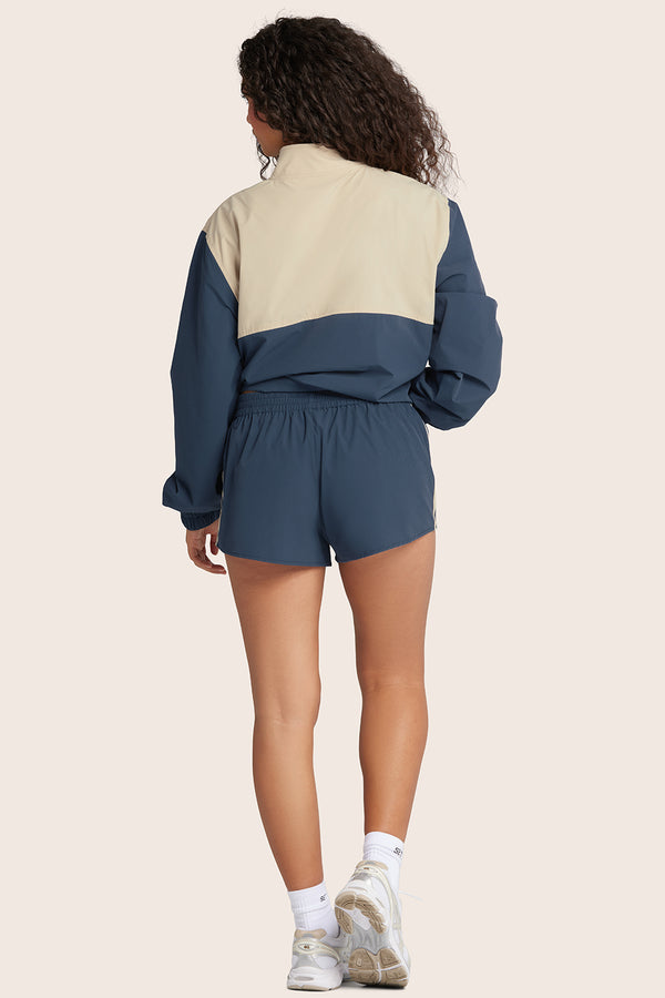 MODEL WEARS NYLON TRACK SHORTS IN COASTAL 