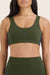 Green sports bra with 'SET' branding worn by a person on a light pink background
