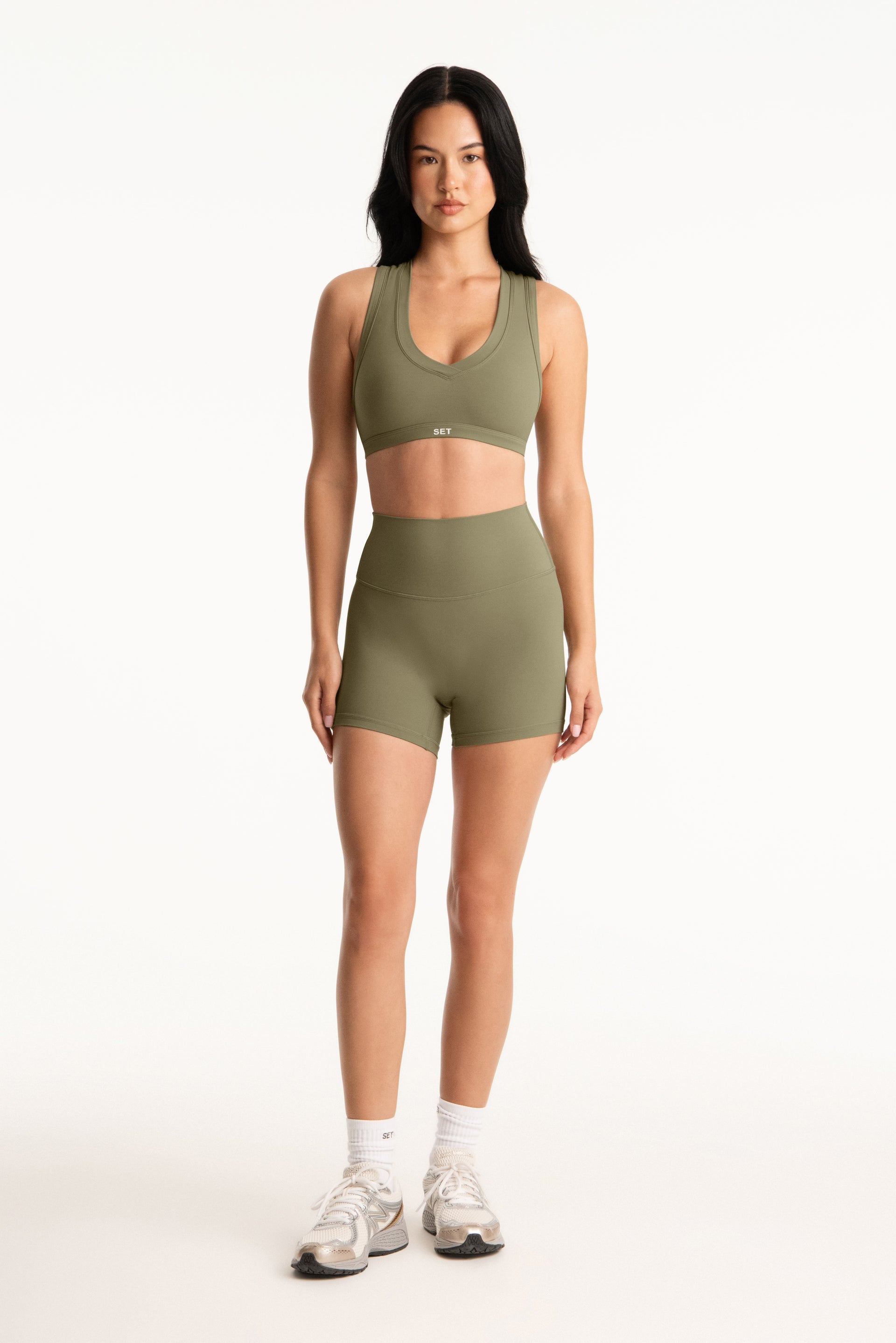 Woman wearing a green athletic outfit on a white background