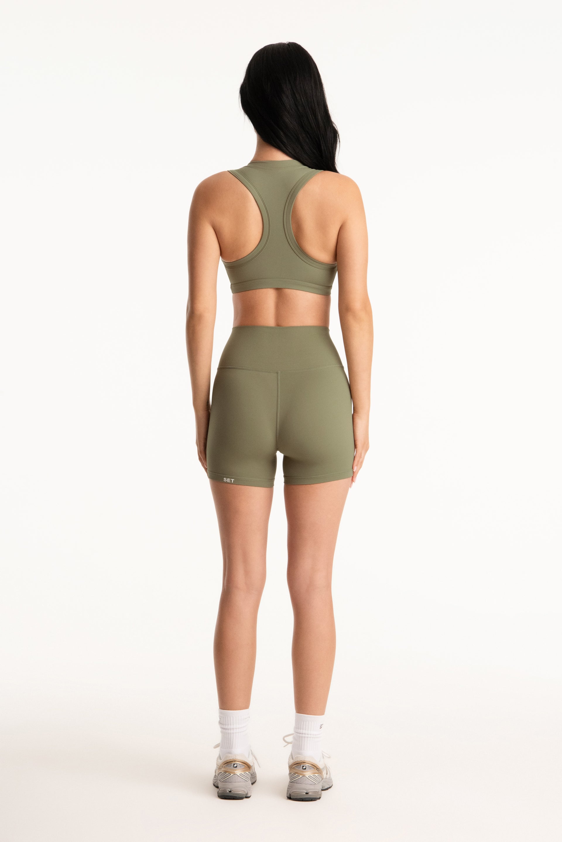 Person wearing a green athletic outfit on a white background