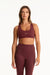 Woman wearing a maroon sports bra and leggings set on a white background <model-info>Presley wears a size S and is 5’6”, 26” waist, 33” bust.</model-info>