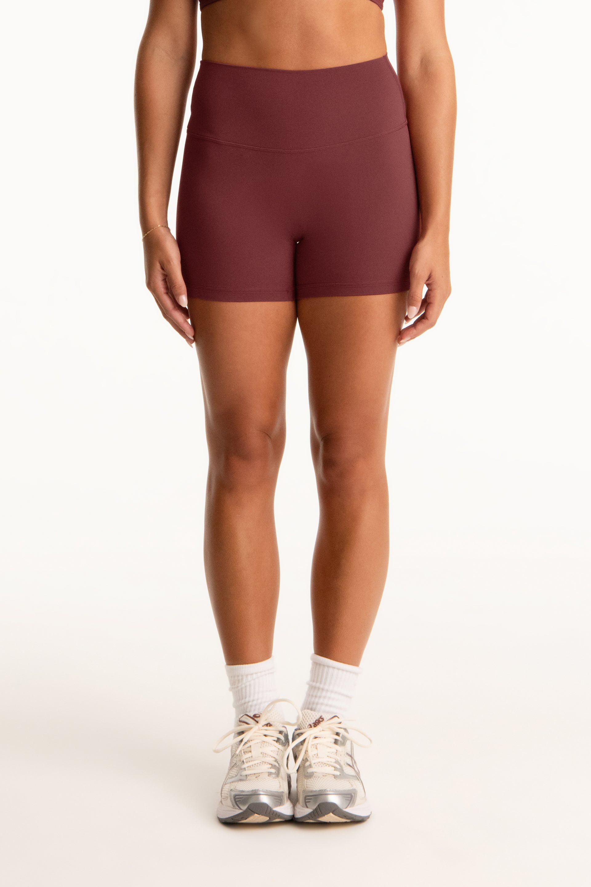 Person wearing maroon shorts on a white background <model-info>Presley wears a size S and is 5’6”, 26” waist, 33” bust.</model-info>