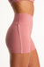 Pink athletic shorts worn by a person on a white background
