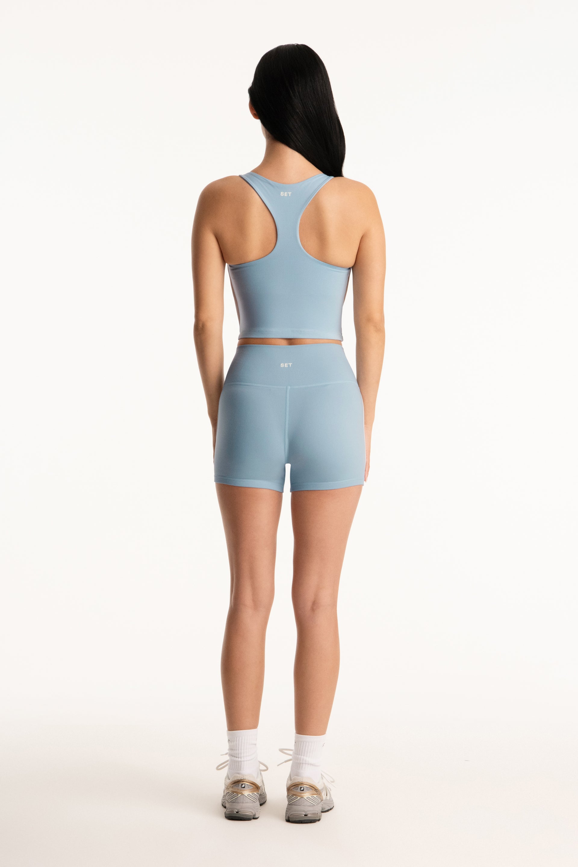 Person wearing a light blue athletic outfit on a white background