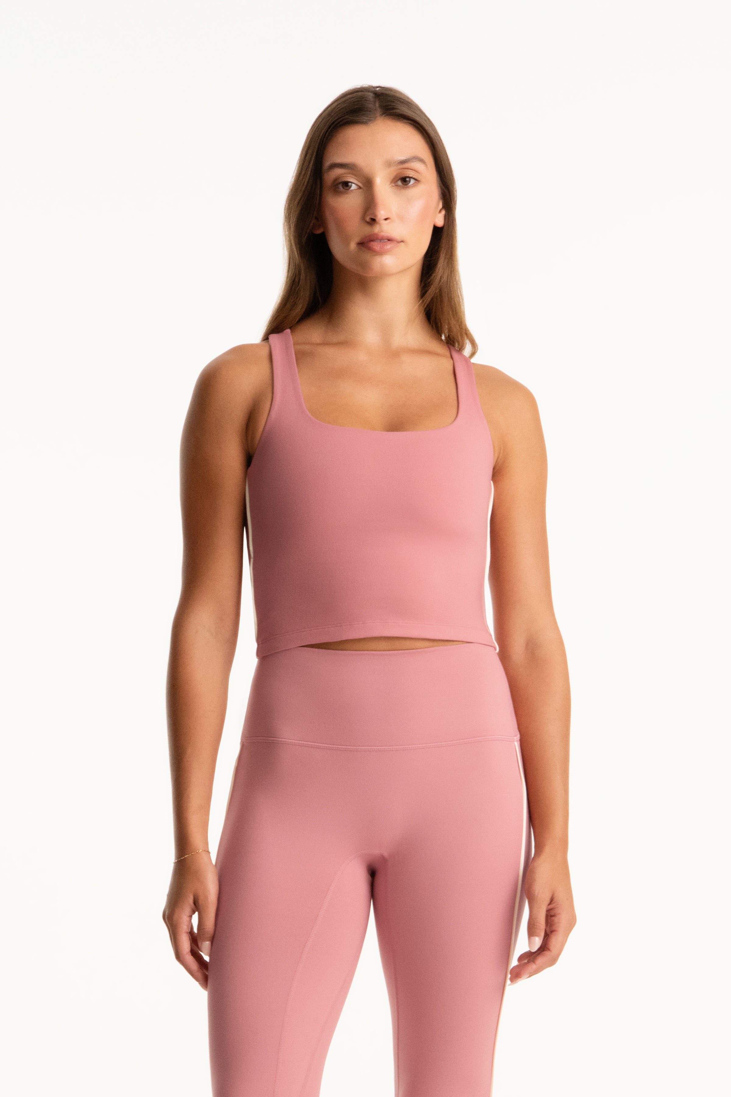 Woman wearing a pink athletic outfit on a white background 