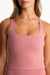 Person wearing a pink tank top against a white background