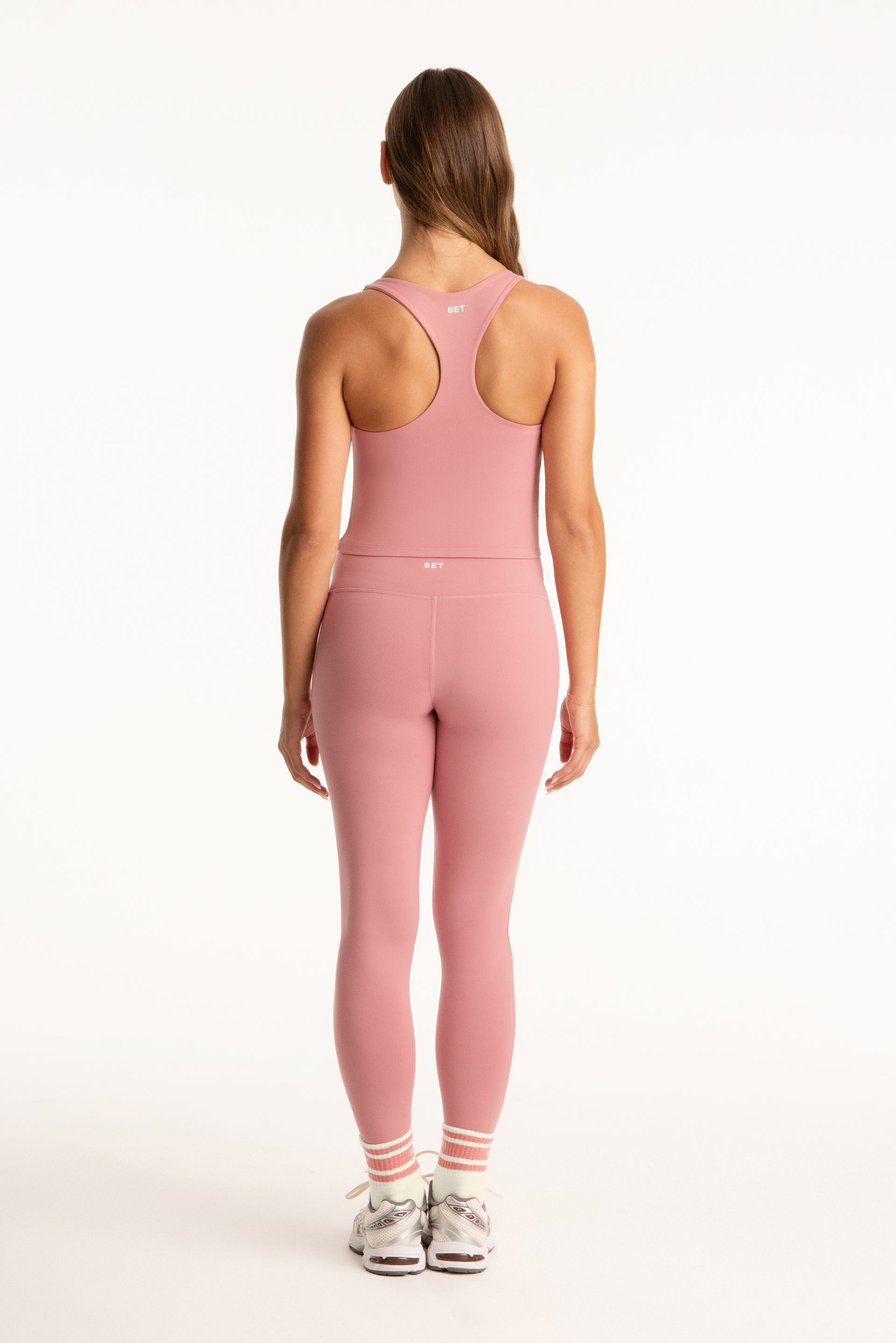 Person wearing a pink athletic outfit on a white background