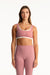 Woman wearing a pink sports bra and leggings set on a white background <model-info>Presley wears a size S and is 5’6”, 26” waist, 33” bust.</model-info>