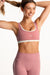 Woman wearing a pink sports bra and leggings with 'SET' branding on a white background <model-info>Presley wears a size S and is 5’6”, 26” waist, 33” bust.</model-info>