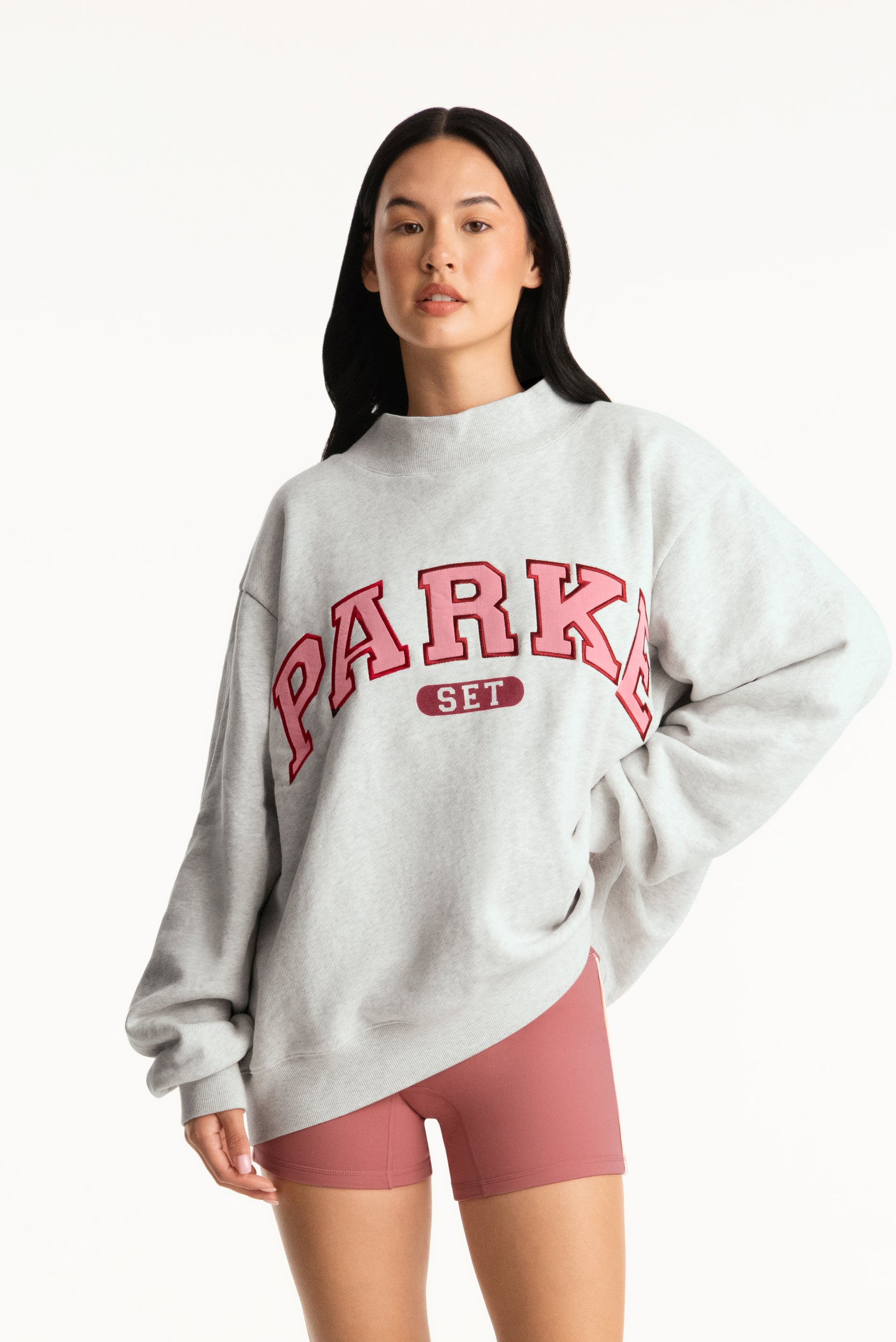 Woman wearing a gray sweatshirt with 'PARK' printed in red on a white background <model-info>Jasmine wears a size L/XL and is 5’8”, 25" waist, 36” bust.</model-info>