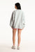 Person wearing a light gray oversized sweatshirt and pink shorts on a white background