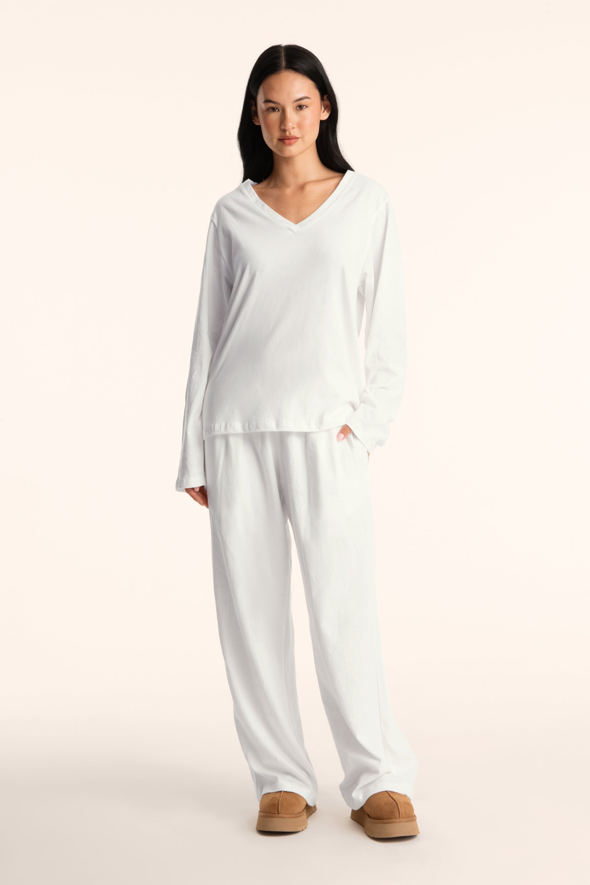 Woman wearing a white outfit on a plain background