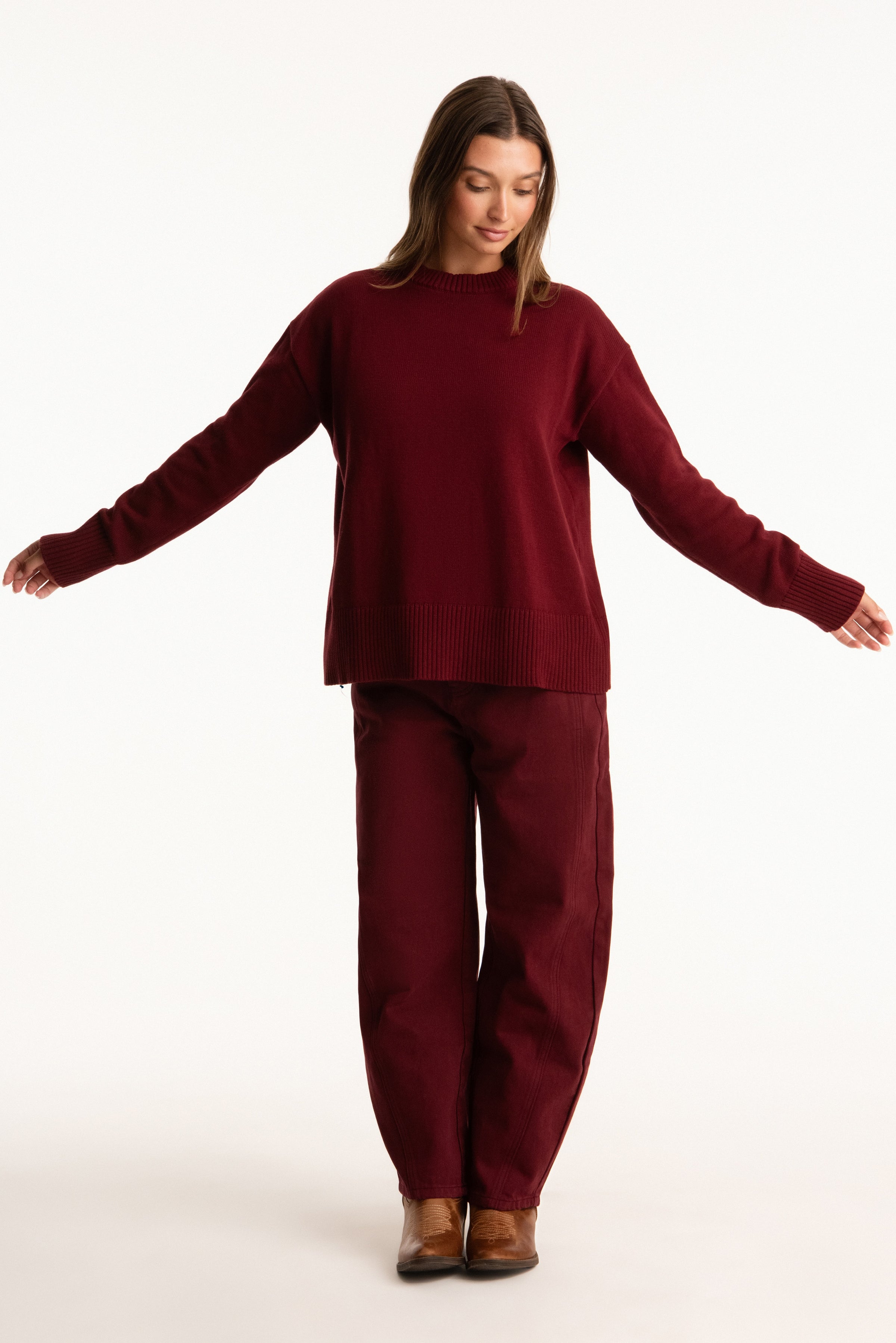 Woman wearing a burgundy outfit on a white background