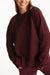 Person wearing a maroon sweater on a white background
