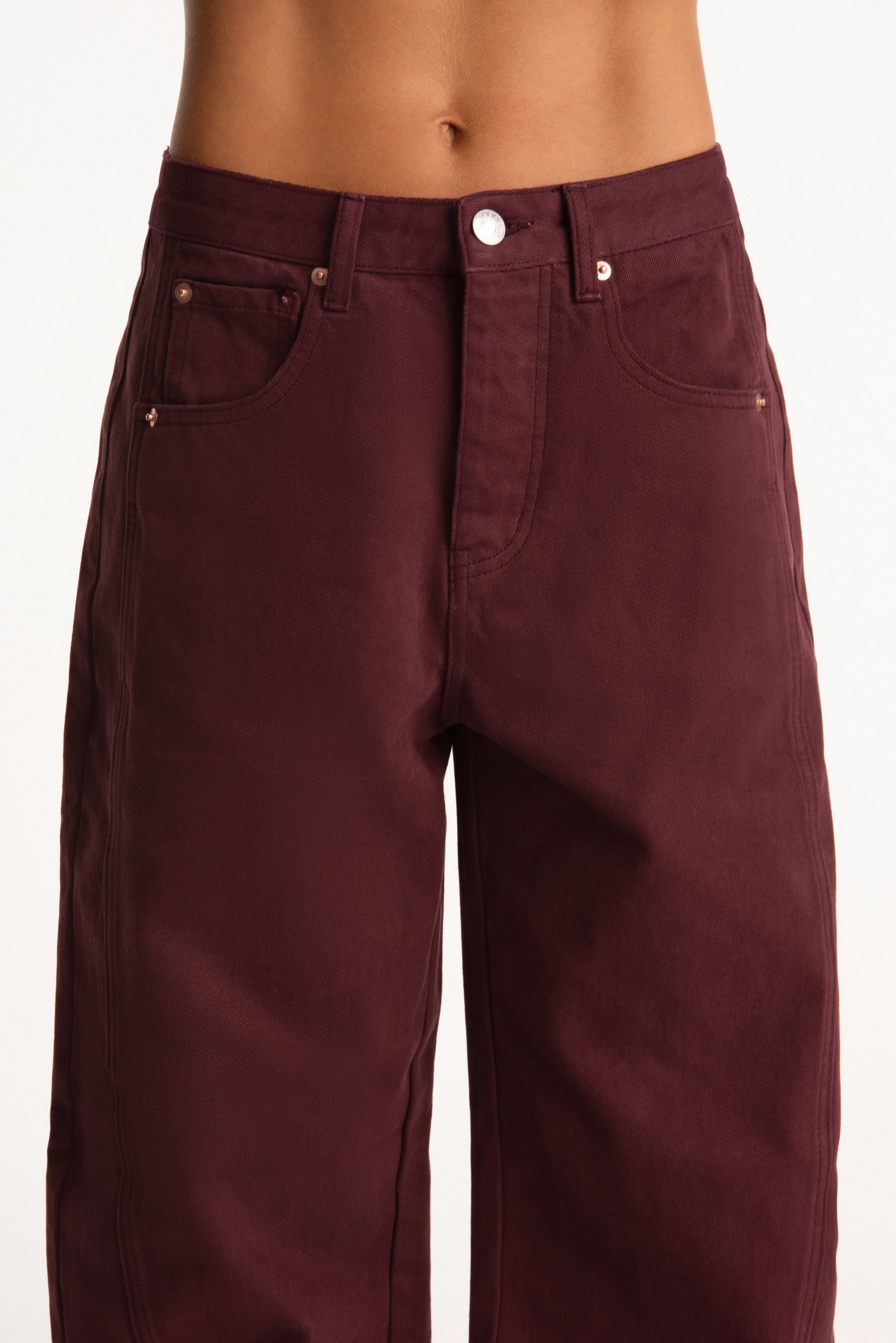 Maroon pants worn by a person on a white background