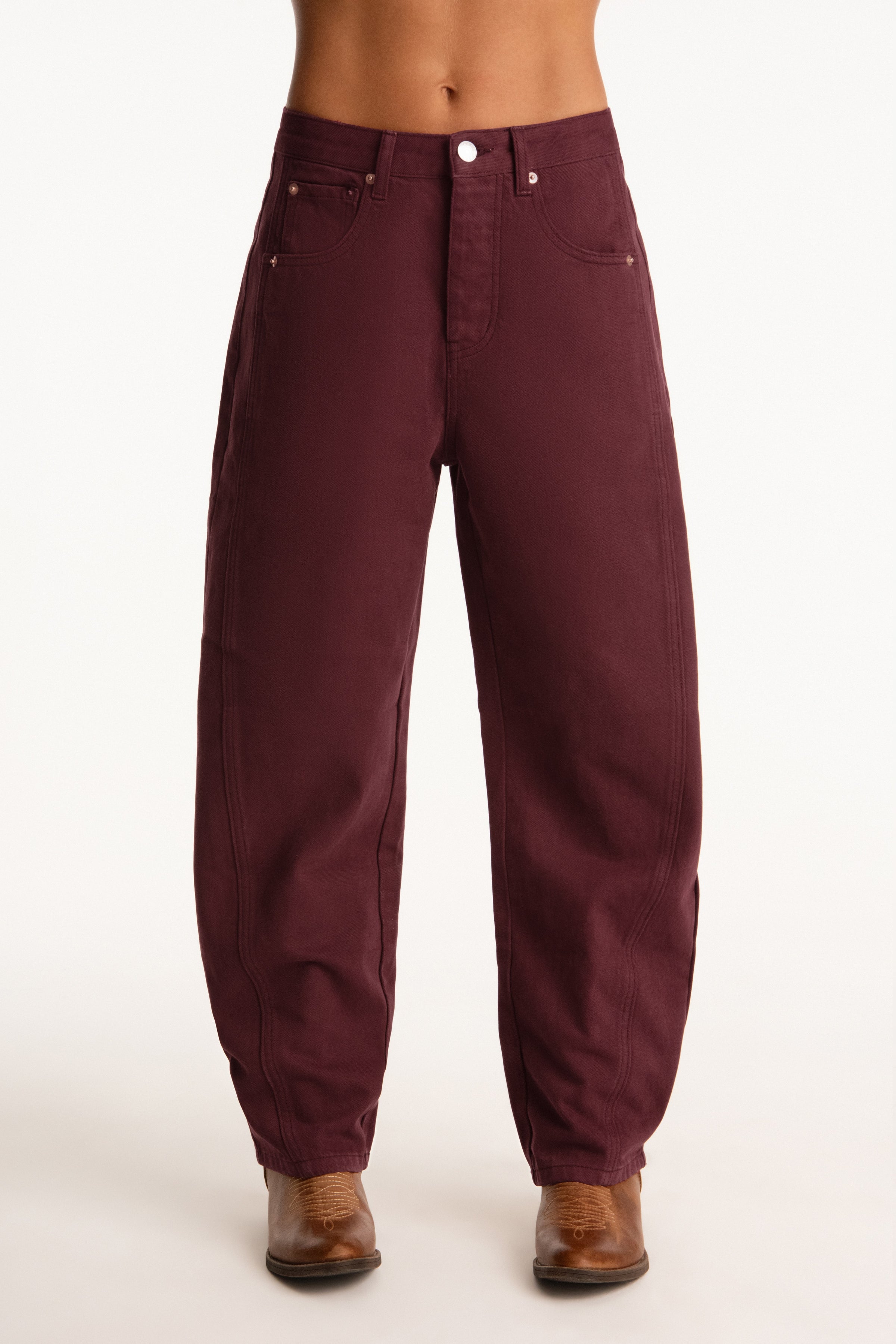 Maroon pants worn by a person on a white background 