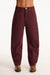 Maroon pants worn by a person on a white background <model-info>Presley wears a size 25 and is 5’6”, 26” waist, 33” bust.</model-info>