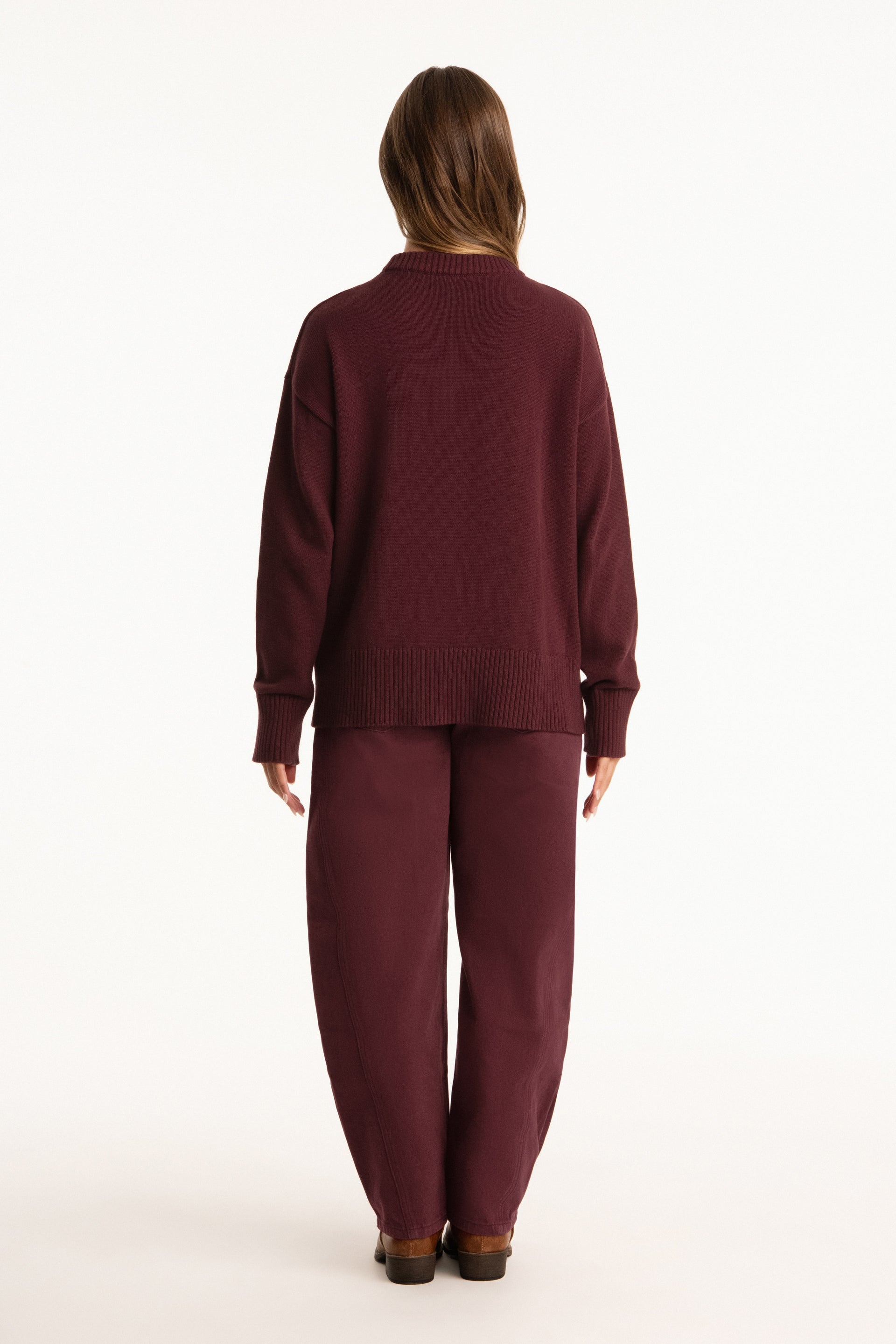 Person wearing a burgundy outfit on a white background