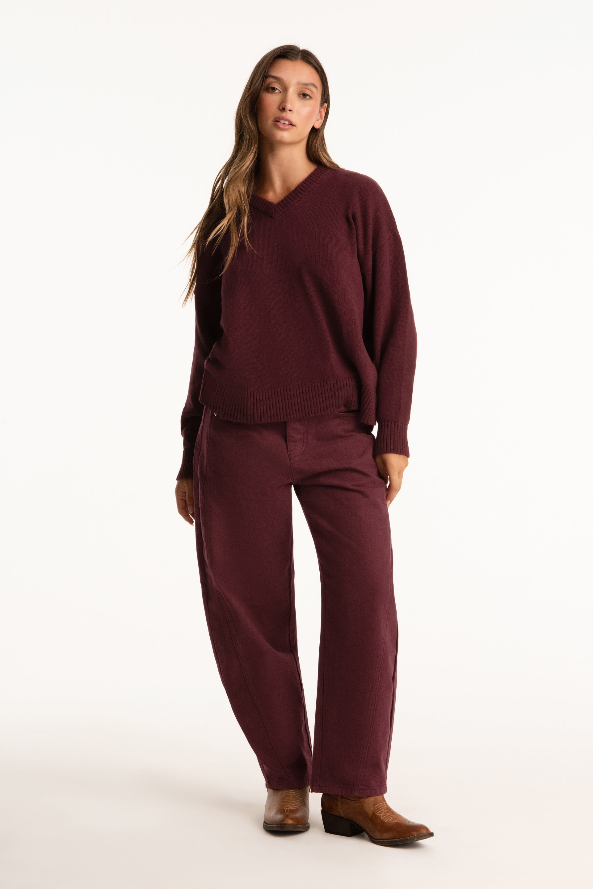 Woman wearing a burgundy outfit on a white background