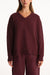 Maroon sweater worn by a person on a white background