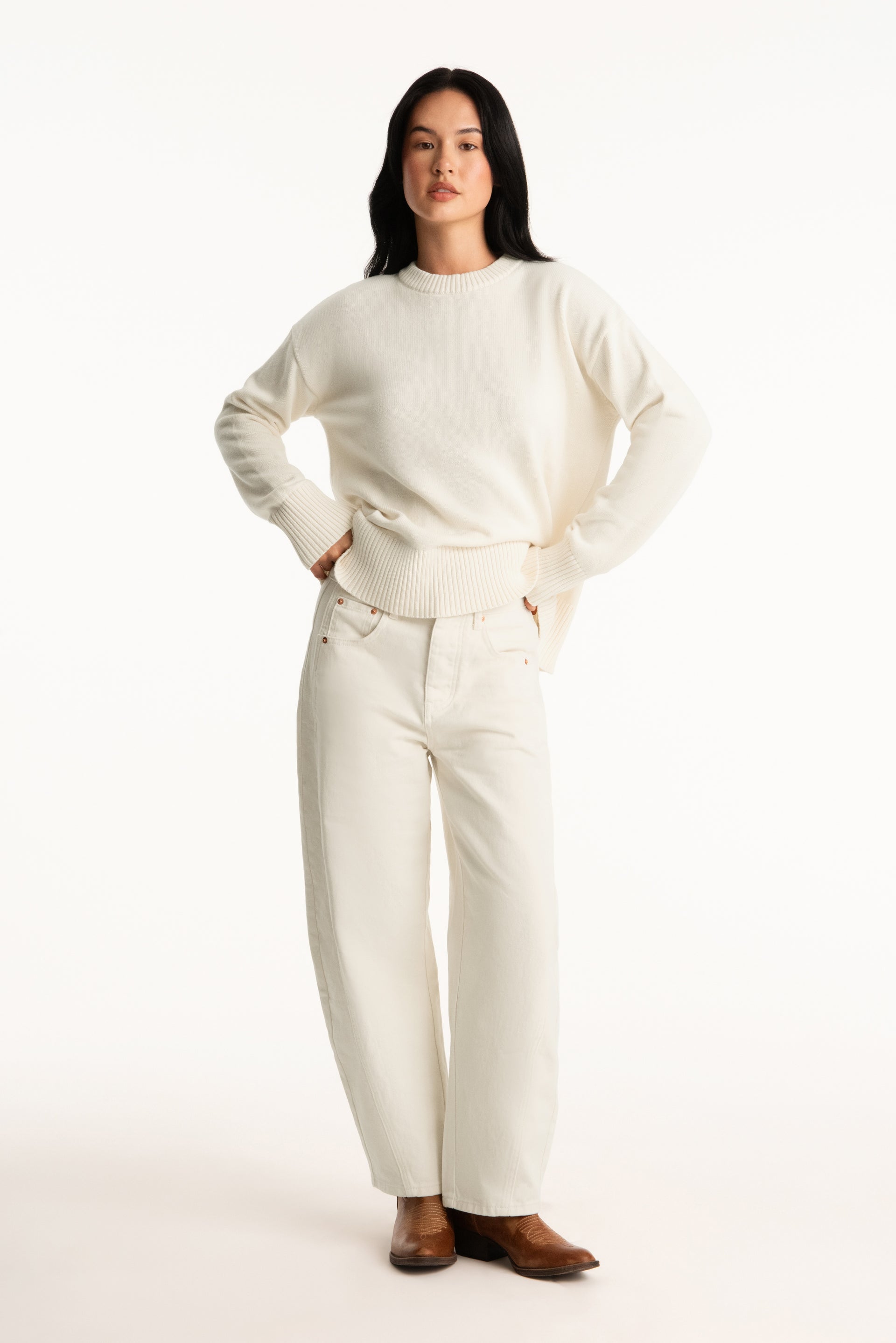 Woman wearing a white sweater and pants on a white background