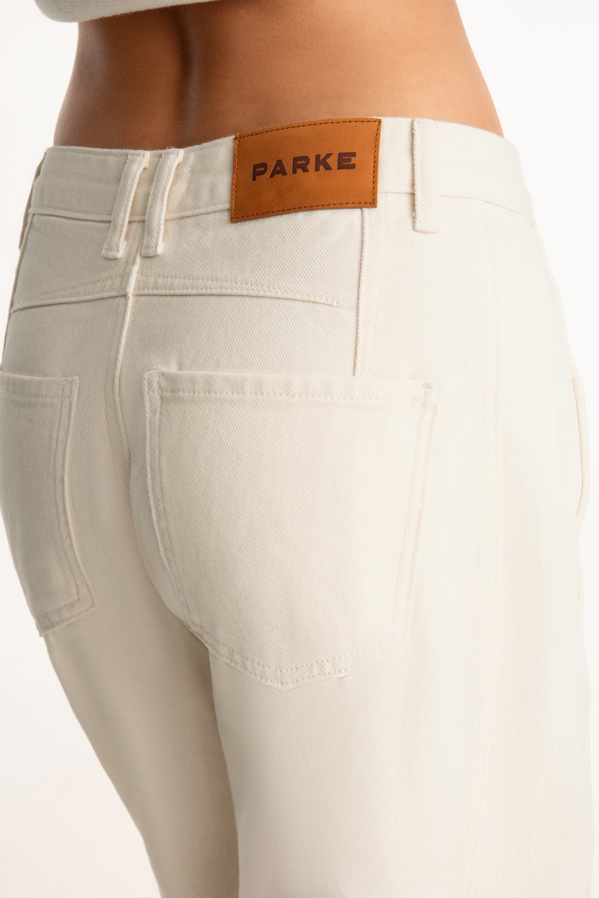 Beige pants with a visible brand label on a white background