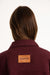 Person wearing a maroon jacket with a 'Parke' patch on a white background